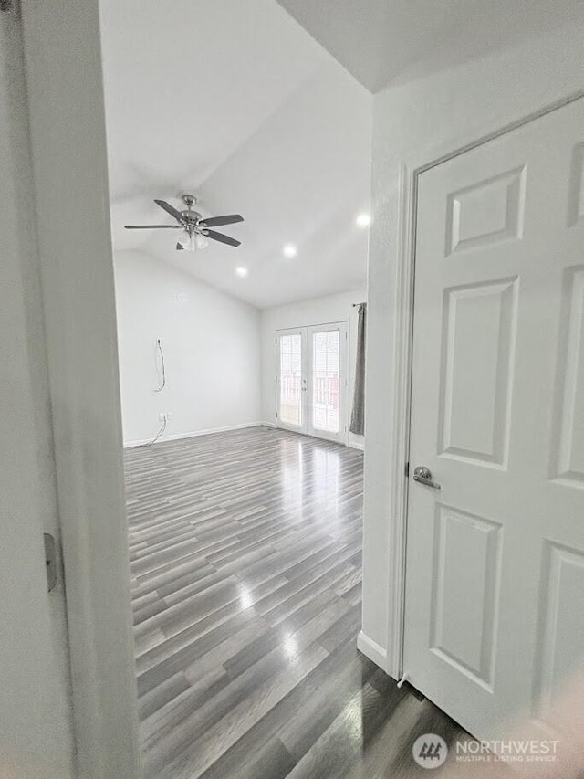 empty room featuring baseboards, lofted ceiling, dark wood-style flooring, and french doors