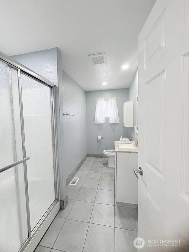 full bathroom featuring vanity, visible vents, a stall shower, tile patterned floors, and toilet