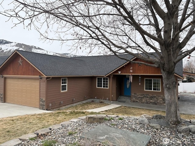 view of front facade with a garage, stone siding, roof with shingles, and driveway