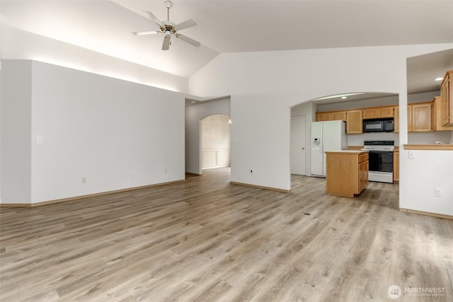 unfurnished living room with high vaulted ceiling, a ceiling fan, arched walkways, light wood finished floors, and baseboards