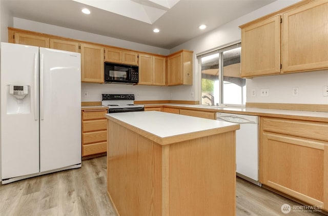 kitchen featuring white appliances, light brown cabinets, light wood-style floors, and a sink