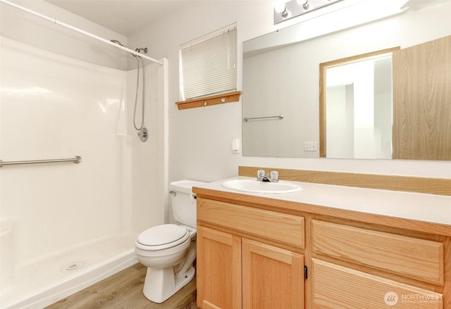 full bathroom with vanity, wood finished floors, toilet, and a shower