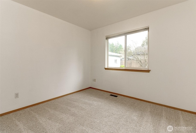 unfurnished room featuring baseboards, visible vents, and carpet floors