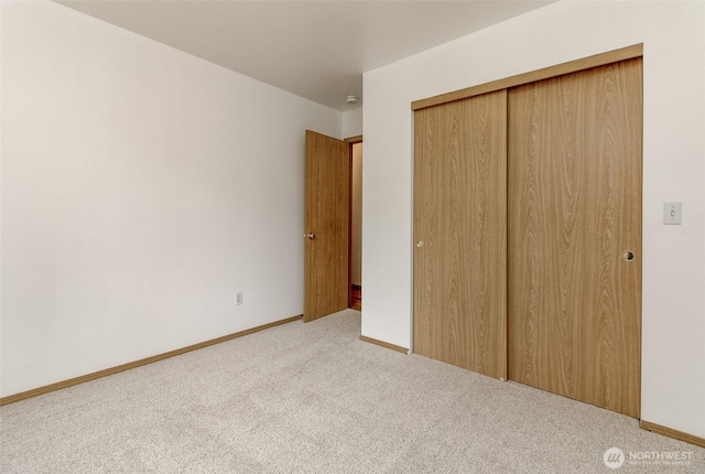 unfurnished bedroom featuring a closet, baseboards, and carpet