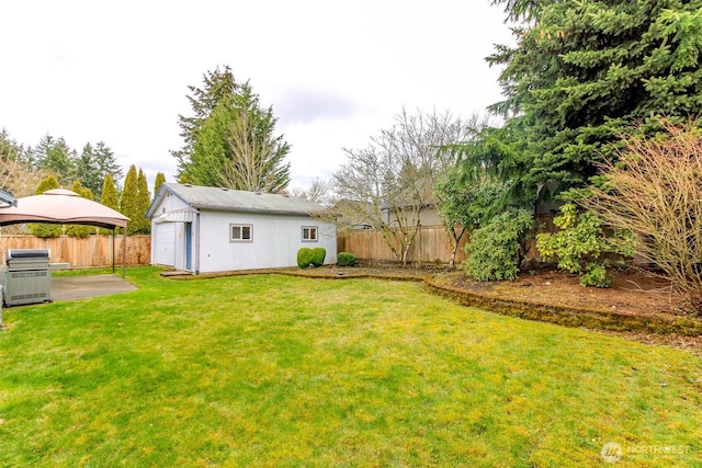 view of yard featuring a patio area, an outdoor structure, and a fenced backyard