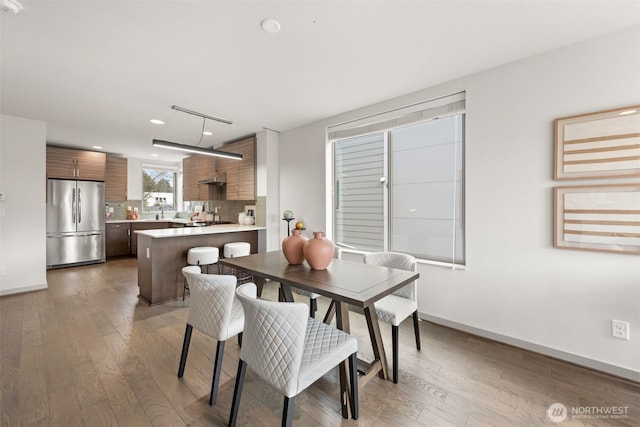 dining area with baseboards and wood-type flooring