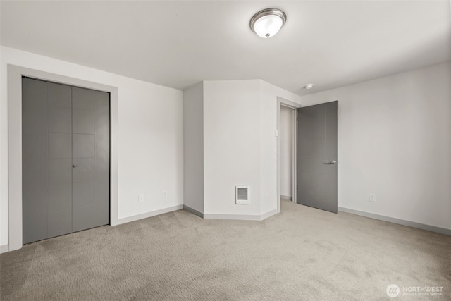 unfurnished bedroom featuring a closet, carpet flooring, baseboards, and visible vents