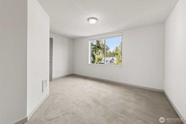 unfurnished room with carpet flooring, visible vents, and baseboards