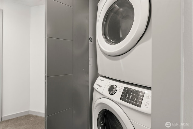 laundry room with stacked washer / dryer, laundry area, and baseboards