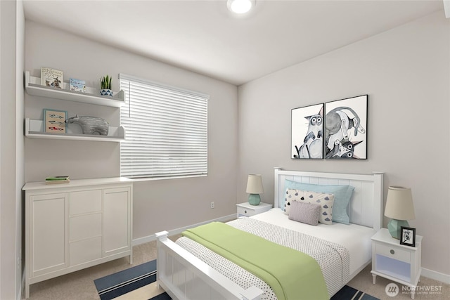 bedroom with baseboards and light colored carpet