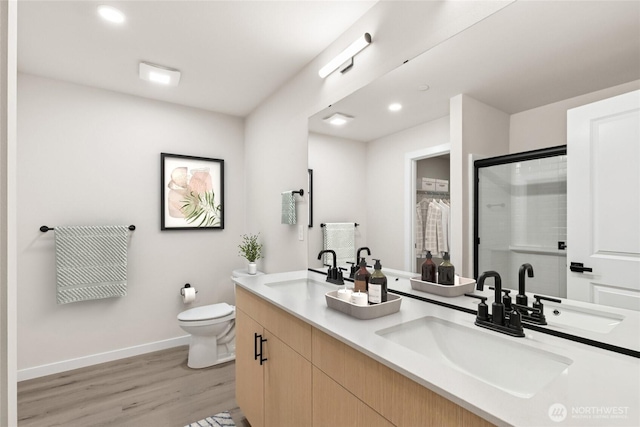 bathroom with a sink, toilet, and a shower stall