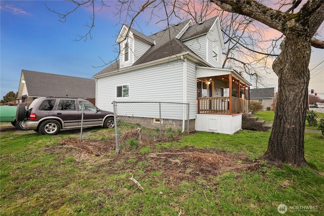 view of side of property with a yard and roof with shingles