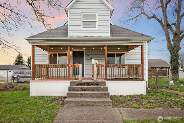 bungalow-style house featuring a porch, a gate, fence, and roof with shingles