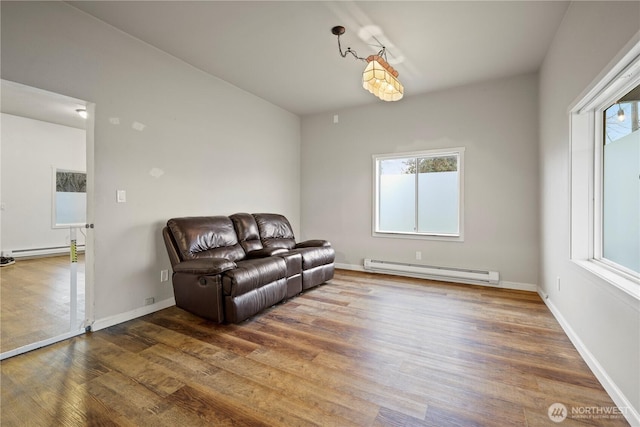 sitting room with a baseboard radiator, baseboards, baseboard heating, and wood finished floors