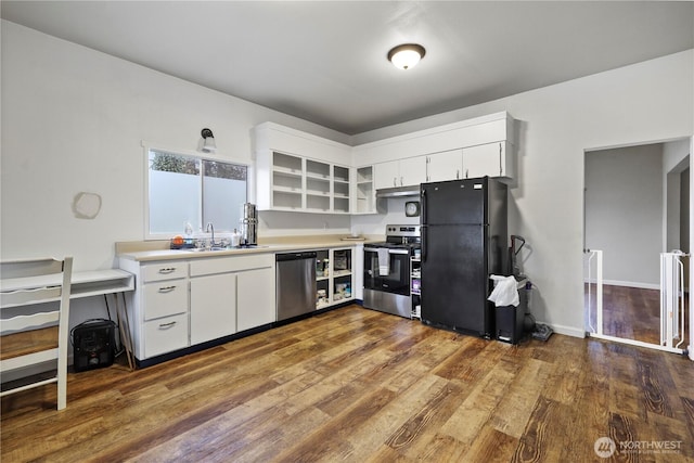 kitchen featuring light countertops, stainless steel appliances, wood finished floors, white cabinetry, and a sink