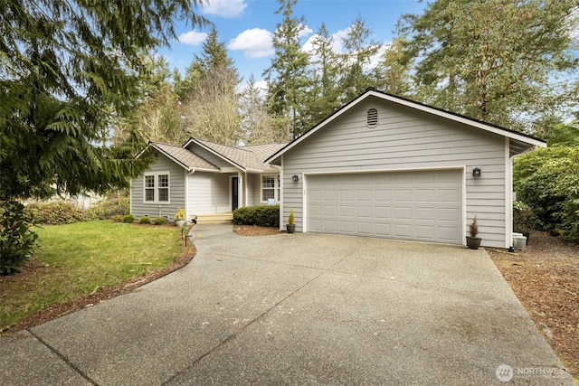 ranch-style house featuring an attached garage, concrete driveway, and a front lawn