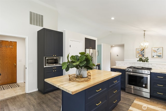 kitchen with vaulted ceiling, visible vents, appliances with stainless steel finishes, and wooden counters