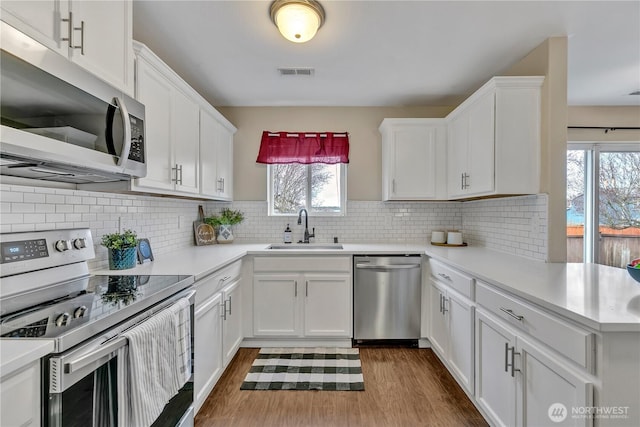 kitchen with visible vents, appliances with stainless steel finishes, light countertops, and a sink