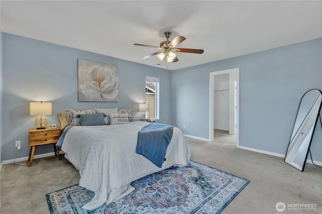 bedroom with baseboards, a ceiling fan, a spacious closet, and carpet flooring