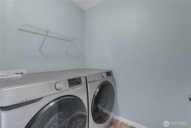 laundry room with laundry area, baseboards, and separate washer and dryer