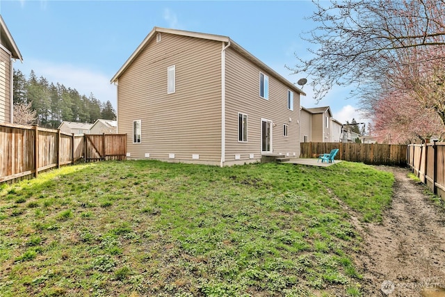 back of house featuring a lawn, a patio, and a fenced backyard