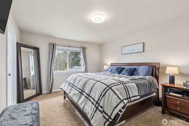 bedroom with light colored carpet and baseboards