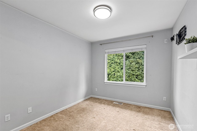 carpeted spare room with baseboards and visible vents