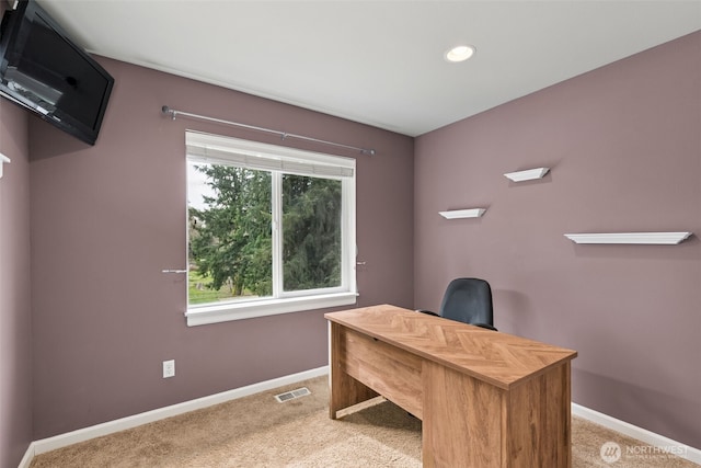 office space featuring baseboards, light carpet, and visible vents