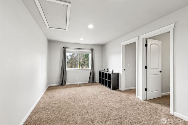 carpeted empty room with recessed lighting, attic access, and baseboards