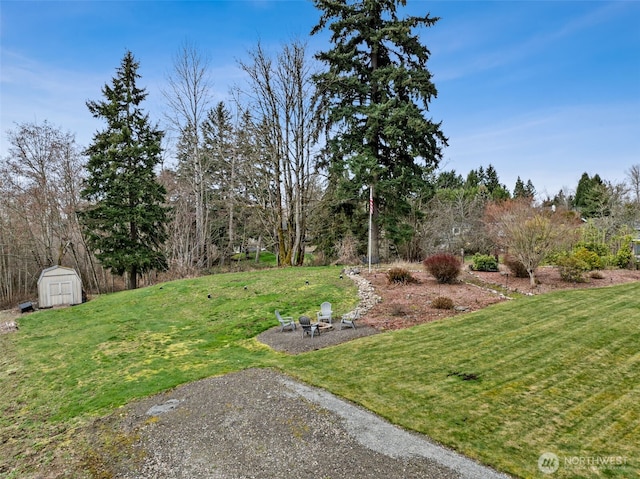 view of yard featuring a storage shed, an outbuilding, and an outdoor fire pit