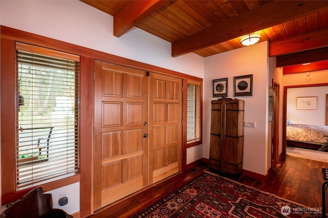 entrance foyer featuring beamed ceiling, dark wood-style flooring, baseboards, and wooden ceiling