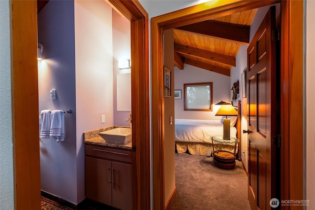 hall with dark colored carpet, a sink, wood ceiling, and lofted ceiling with beams