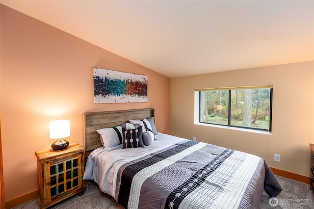 bedroom with vaulted ceiling, baseboards, and carpet flooring