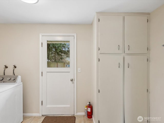 washroom with cabinet space, washer / dryer, baseboards, and light tile patterned flooring