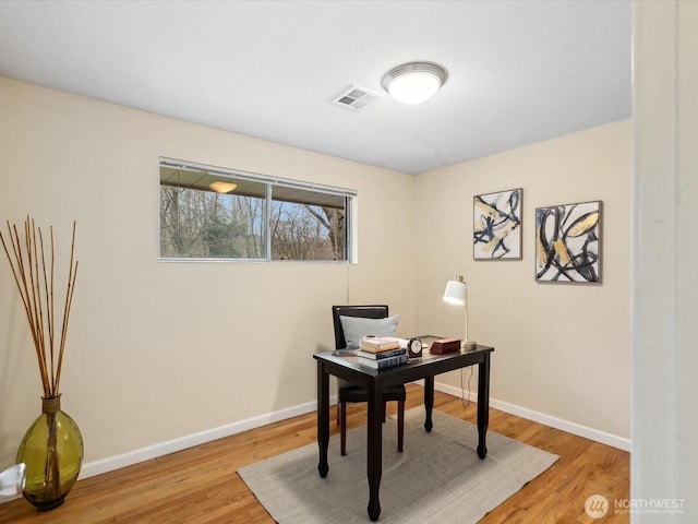 office space with visible vents, baseboards, and wood finished floors