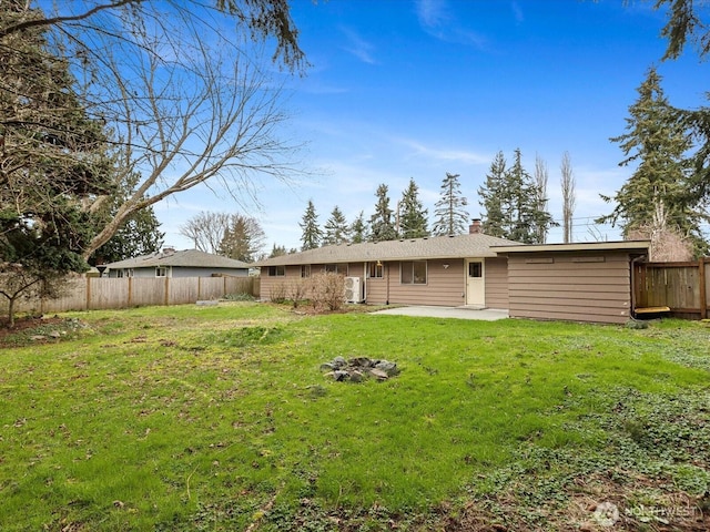 rear view of house with a lawn, a chimney, a patio, and fence