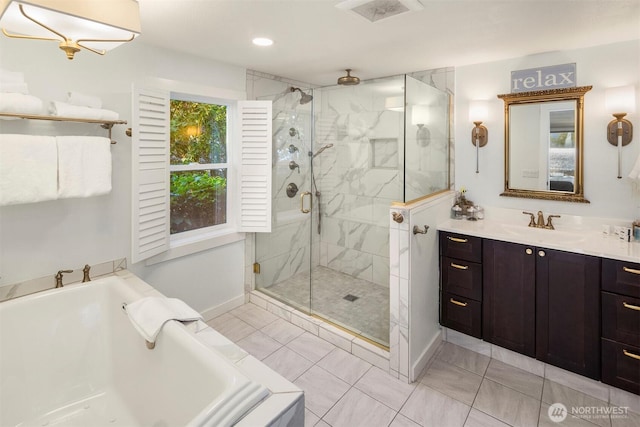 full bath with vanity, baseboards, visible vents, a stall shower, and a bath