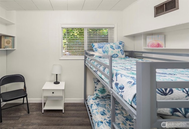 bedroom featuring visible vents, baseboards, dark wood-style floors, and ornamental molding