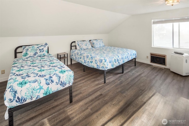 bedroom featuring heating unit, baseboards, lofted ceiling, and wood finished floors