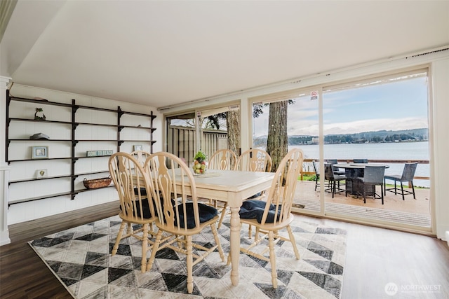 dining room with wood finished floors and a water view