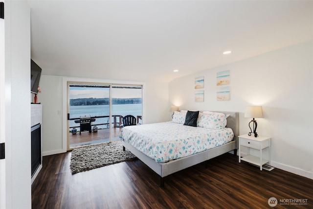 bedroom with a large fireplace, baseboards, recessed lighting, dark wood-style floors, and access to outside