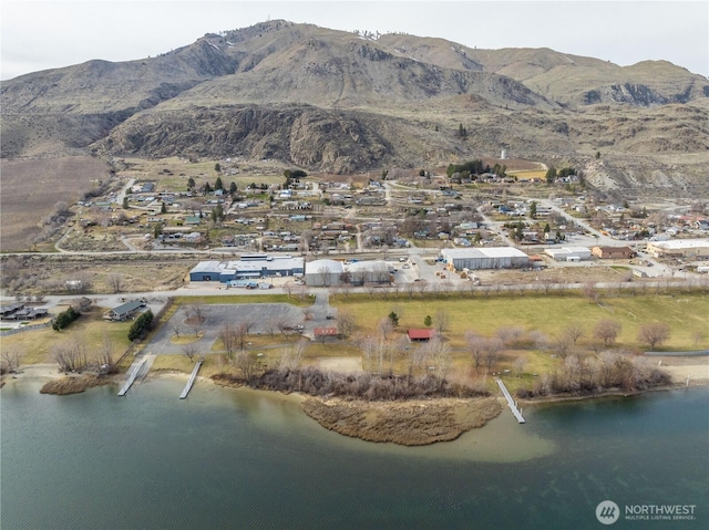 birds eye view of property with a water and mountain view