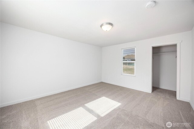 unfurnished bedroom featuring a closet, baseboards, and carpet flooring