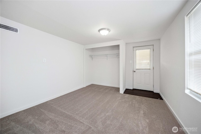 unfurnished bedroom with a closet, visible vents, baseboards, and carpet floors