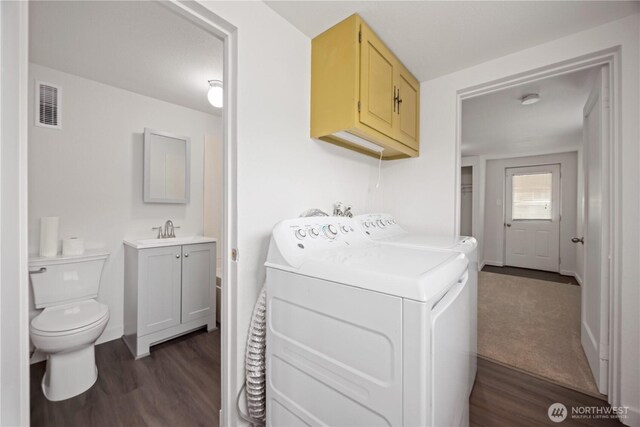 laundry area with visible vents, baseboards, dark wood-type flooring, and washing machine and dryer