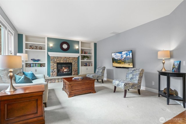 carpeted living room with baseboards, built in shelves, and a fireplace