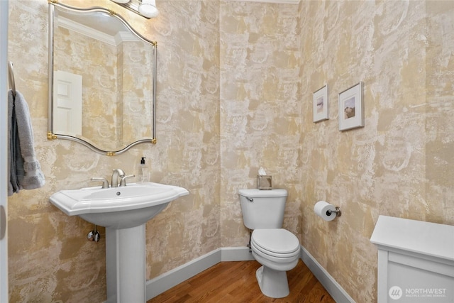 half bath featuring toilet, baseboards, and wood finished floors