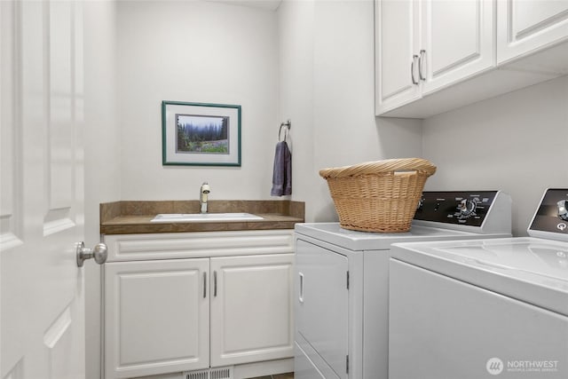 laundry area featuring cabinet space, independent washer and dryer, and a sink