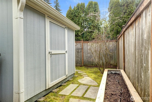 view of shed with a fenced backyard and a garden