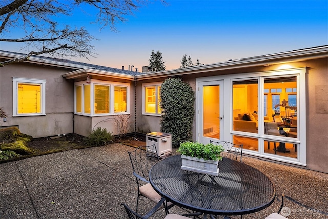 rear view of property featuring stucco siding, outdoor dining space, and a patio area